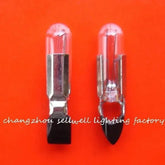 Two clear telephone light bulbs with metal bases on an orange background